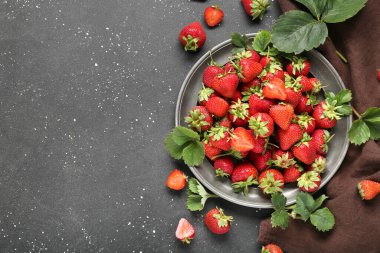 Siyah arka planda tatlı olgun çilek tabağı