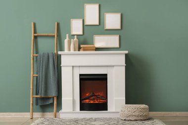 Mavi duvarın yanında merdiveni, koltuğu ve şöminesi olan oturma odasının içinde.