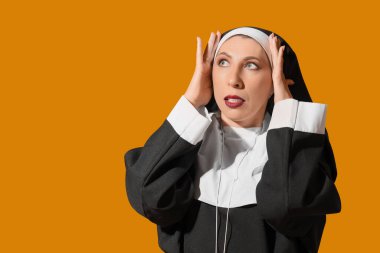 Sarı arka planda rahibe gibi giyinmiş olgun bir kadın. Cadılar Bayramı