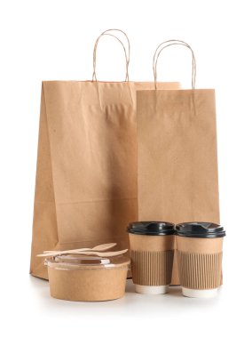 Beyaz arka planda bir kase yiyecek ve kahve fincanı olan kağıt torbalar. Yemek dağıtım servisi.