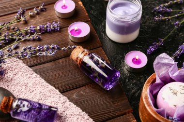 Kozmetik ürünleri, spa aksesuarları ve lavanta çiçekleri ile koyu arka planda, yakın plan