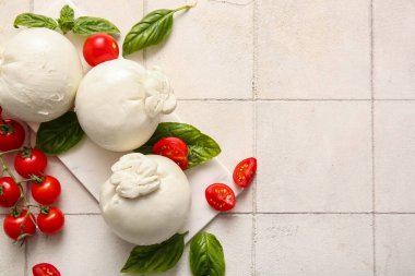 Beyaz fayanslı fesleğenli ve domatesli lezzetli Burrata peyniri.