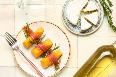 Prosciutto, peynir ve şaraplı lezzetli kavun tabağı.