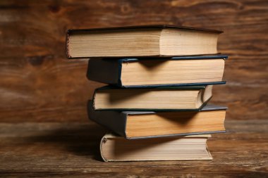 Ahşap zemin üzerine eski ciltli kitap yığını, yakın plan