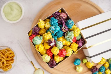 Kovalar dolusu renkli patlamış mısır ve beyaz arka planda kraker.