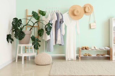 Şık giysili, çiçekli ve raflı aydınlatma odasının içinde.