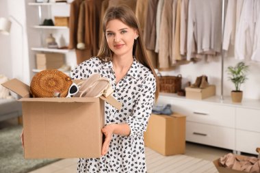 Soyunma odasında farklı aksesuarları olan güzel, genç ve mutlu bir kadın.