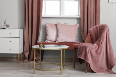 Pencerenin yanında yumuşak bir bank olan oturma odasının şık bir iç mekanı.