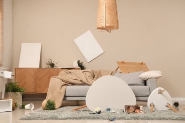 Kanepe, masa ve bitkilerle dolu dağınık bir oturma odası.