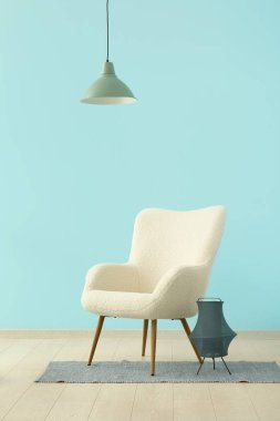 Mavi duvarın yanında beyaz koltuk ve lamba