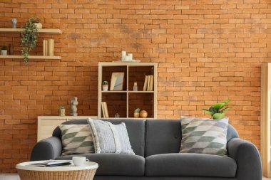 Oturma odası, siyah kanepe ve raf ünitesi.