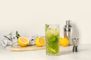 Limonlu bir bardak limonata ve beyaz arka planda nane şekeri.