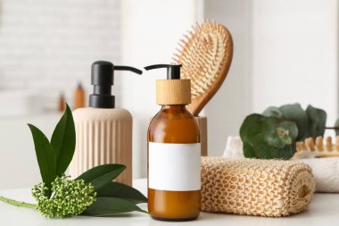 Banyodaki masada kozmetik ürünler ve banyo malzemelerinin bulunduğu güzel bir kompozisyon.