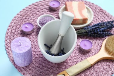 Havanda lavanta, hasır hasırda ve mavi arka planda mumlarla güzel bir kompozisyon, yakın plan.