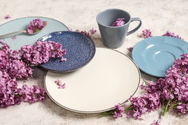 Beyaz grunge arkaplan üzerinde leylak çiçekleri ile güzel masa ayarları, yakın çekim