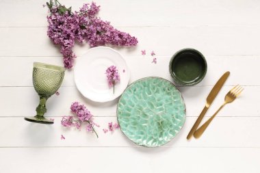 Beyaz ahşap arka planda leylak çiçekleri olan güzel bir masa.