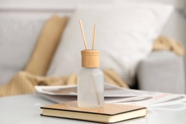 Reed dağıtıcısı, kitap ve dergiler evdeki sehpanın üzerinde.