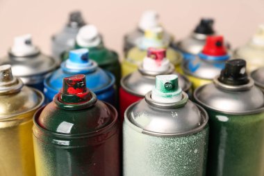 Bej arka planda birçok sprey boya kutusu, yakın plan