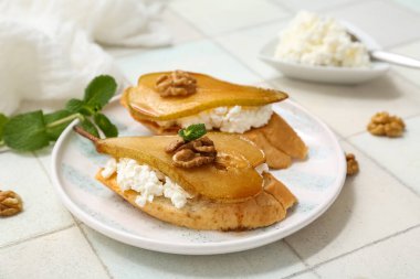 Beyaz fayanslı fındık ve ricotta peynirli armut bruschetta tabağı.