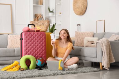 Oturma odasında bavullu güzel bir kadın. Seyahat kavramı