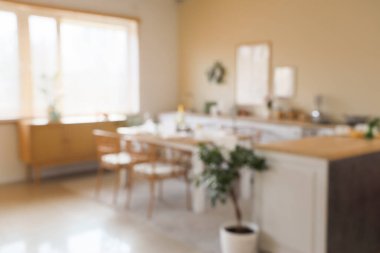 Paskalya için dekore edilmiş mutfak manzarası yemek masası ve tezgahlarla bulanık.