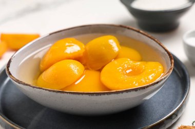 Bir kase lezzetli şeftali konservesi Işık masasında, yakın plan