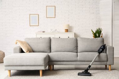 Modern elektrik süpürgesi oturma odasında halının üstünde.
