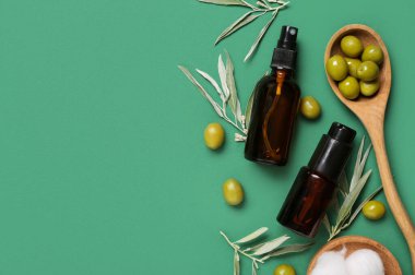 Doğal kozmetik ürünleri şişeleri, yeşil zeytinler ve renk arkaplan dalları ile kompozisyon