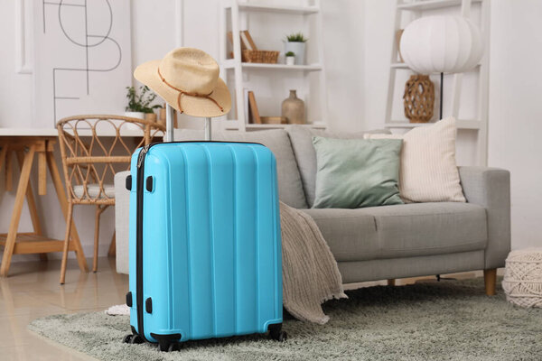 Чемодан в шляпе в гостиной. Концепция путешествия