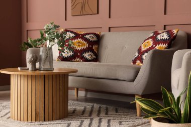 Kanepesi, çiçekleri ve kahve masası olan şık bir oturma odası.