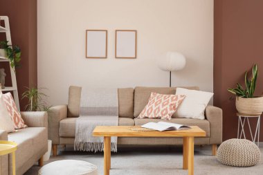 Gri kanepeleri, çiçekleri ve kahve masası olan şık bir oturma odası.