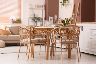 Kanepesi, yemek masası ve çiçekleri olan şık bir açık uzay mutfağı.