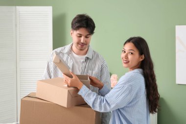 Genç çift evde paket kutularını boşaltıyor.