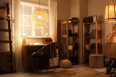 Rahat çalışma alanı, parlayan lamba ve akşamları kitap rafları olan şık bir oda.