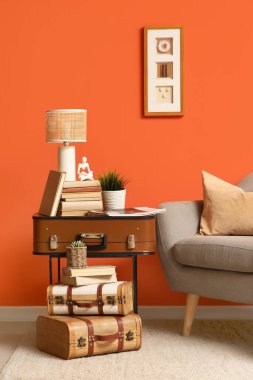 Koltuklu, antika valizli, kitaplı ve kahve masalı şık bir oturma odası.