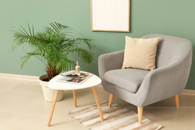 Gri koltuklu, çiçekli ve kahve masalı şık bir oturma odası.