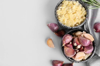 Taze sarımsak karanfilli kase ve gri arka planda biberiye.