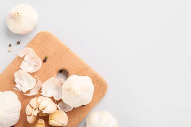 Taze sarımsaklı ahşap tahta ve gri arka planda biber.