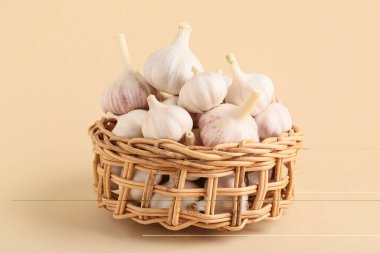 Bej arka planda taze sarımsaklı hasır kase.