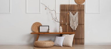 Ağaç dalları ve bayram salonundaki bankta Paskalya yumurtaları olan vazo.