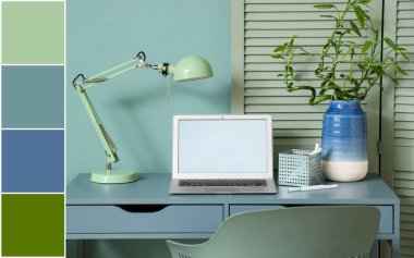 Modern dizüstü bilgisayarı ve nane duvarının yanında lambası olan rahat bir iş yeri. Farklı renk desenleri