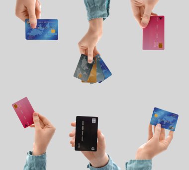 Gri arka planda kredi kartı olan birçok kişi