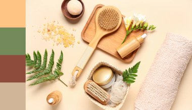 Renkli arkaplanda spa aksesuarları, kozmetik ürünleri ve eğreltiotu yaprakları ile kompozisyon