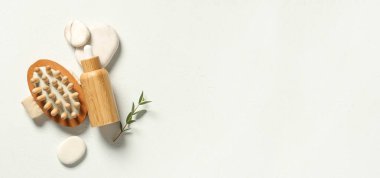 Gerekli yağ şişesi, masaj fırçası ve renk arkaplan üzerine spa taşları