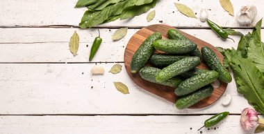 Hafif ahşap arka planda taze salatalık korunması için kurulmuş.