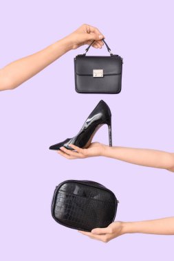 Farklı tarz çantalar tutan kadın eller ve leylak arka planda yüksek topuklar.