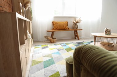 Oturma odasının içinde ahşap bank ve raf ünitesi var.