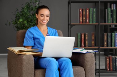 Kütüphanede dizüstü bilgisayarla çalışan bir tıp öğrencisi.