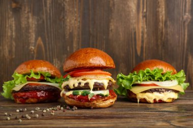 Ahşap arka planda lezzetli hamburgerler