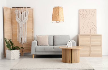 Oturma odasının içinde rahat bir kanepe, sehpa ve çekmeceler var.